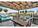 Outdoor dining area under a pergola, complete with pool, lounge seating and grill at 7114 Fern Garden Ct, Sun City Center, FL 33573