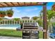 Outdoor cooking area showcasing a grill on a patio with pergola, and a pool, perfect for entertaining at 7114 Fern Garden Ct, Sun City Center, FL 33573