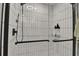 Close-up of the tiled shower with glass door and black hardware, offering a contemporary and luxurious feel at 7114 Fern Garden Ct, Sun City Center, FL 33573