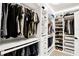 Well-organized walk-in closet with custom shelving, drawers, and rods for clothes and shoe storage at 7114 Fern Garden Ct, Sun City Center, FL 33573