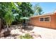 The backyard features a brick patio, a dining table under an umbrella, and is surrounded by lush greenery at 7401 11Th N Ave, St Petersburg, FL 33710