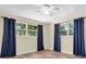 Bright bedroom with wood-look flooring, windows, and modern ceiling fan at 7401 11Th N Ave, St Petersburg, FL 33710