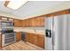 Galley kitchen with stainless steel appliances, wood cabinets, and light countertops at 7401 11Th N Ave, St Petersburg, FL 33710