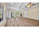 Bright living room featuring wood-look flooring, ceiling fan, and multiple windows for ample natural light at 7401 11Th N Ave, St Petersburg, FL 33710
