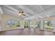 Bright living room featuring wood-look flooring, ceiling fan, and multiple windows offering natural light at 7401 11Th N Ave, St Petersburg, FL 33710