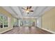 Bright living room with ceiling fan, multiple windows offering natural light, and wood-look flooring at 7401 11Th N Ave, St Petersburg, FL 33710