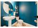 Stylish powder room features modern pedestal sink, gold fixtures, and beautiful blue accent wall at 790 36Th N Ave, St Petersburg, FL 33704
