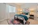 Bedroom features a dark metal frame bed dressed with teal bedding, side tables, lamps, and patterned rug at 790 36Th N Ave, St Petersburg, FL 33704