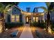 Charming home with manicured lawn, lush landscaping, and a welcoming walkway at night at 790 36Th N Ave, St Petersburg, FL 33704