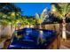 Backyard spa at night with a wooden surround, palm trees, and landscape lighting at 790 36Th N Ave, St Petersburg, FL 33704