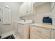 Well-equipped laundry room featuring modern washer, dryer, white cabinetry, and countertops at 790 36Th N Ave, St Petersburg, FL 33704