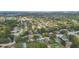 An aerial view displaying neighborhood homes nestled among lush trees with a glimpse of the Gulf of Mexico at 854 Village Way, Palm Harbor, FL 34683