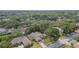 Aerial view of a community, showcasing mature trees surrounding well-maintained homes and properties at 854 Village Way, Palm Harbor, FL 34683
