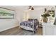 Bright bedroom featuring hardwood floors, a ceiling fan, and a dresser with decorative mirror at 854 Village Way, Palm Harbor, FL 34683