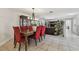 Open dining room area with red upholstered chairs, a wooden table and access to an expansive living area at 854 Village Way, Palm Harbor, FL 34683