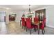 Formal dining area featuring a wooden table, red upholstered chairs, and a decorative china cabinet at 854 Village Way, Palm Harbor, FL 34683