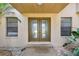 Elegant entryway with frosted double doors and decorative windows surrounded by lush plants at 854 Village Way, Palm Harbor, FL 34683