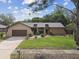 Charming single-story home featuring a well-manicured lawn and a two-car garage at 854 Village Way, Palm Harbor, FL 34683