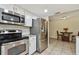 Galley kitchen with stainless steel appliances, white cabinets and granite countertops at 854 Village Way, Palm Harbor, FL 34683