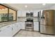 Bright kitchen with white cabinets, stainless steel appliances, granite countertops and a window at 854 Village Way, Palm Harbor, FL 34683
