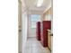 Cozy laundry room with modern red appliances, overhead storage, and a convenient utility sink at 854 Village Way, Palm Harbor, FL 34683