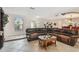 Inviting living room featuring comfortable leather sectional, tile floors, and ample natural light at 854 Village Way, Palm Harbor, FL 34683
