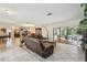 Spacious living room with tile flooring, comfortable leather seating, and access to outdoor patio at 854 Village Way, Palm Harbor, FL 34683