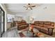 Open-concept living room with kitchen access, hardwood floors, and ceiling fan at 854 Village Way, Palm Harbor, FL 34683