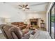 Inviting living room features a stone fireplace, ceiling fan, and access to the outdoor patio at 854 Village Way, Palm Harbor, FL 34683