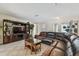 Open-concept living room with tile flooring, leather sectional, and modern entertainment center at 854 Village Way, Palm Harbor, FL 34683