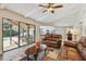 Living room featuring sliding glass doors to the pool area, hardwood floors and access to the kitchen and dining areas at 854 Village Way, Palm Harbor, FL 34683