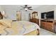 Bright main bedroom with a TV, ensuite bath, and a decorative dresser at 854 Village Way, Palm Harbor, FL 34683