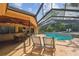 Outdoor lounge chairs and a swimming pool featuring a stone waterfall feature and a screened enclosure at 854 Village Way, Palm Harbor, FL 34683