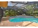 Swimming pool featuring a decorative stone waterfall feature and outdoor lounge chairs at 854 Village Way, Palm Harbor, FL 34683