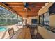 Outdoor dining area next to pool with views of the screened in patio with ceiling fans at 854 Village Way, Palm Harbor, FL 34683