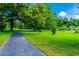Paved walking path winding through green lawns and mature trees, ideal for leisurely strolls and outdoor exercise at 854 Village Way, Palm Harbor, FL 34683