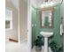 Inviting powder room featuring a pedestal sink, framed mirror, and plenty of natural light streaming through the window at 904 Villa Venicia Way, Tampa, FL 33606