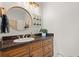 Elegant bathroom featuring a round mirror, designer lighting and dark countertops at 904 Villa Venicia Way, Tampa, FL 33606