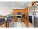 Contemporary kitchen featuring dark granite countertops, wooden cabinets, and stainless steel appliances for meal preparation at 904 Villa Venicia Way, Tampa, FL 33606