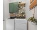 Well-lit laundry area features green cabinets and stylish palm leaf wallpaper at 904 Villa Venicia Way, Tampa, FL 33606