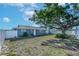 Spacious backyard with a large tree, privacy fence, and well-maintained lawn at 906 Hacienda Dr, Sun City Center, FL 33573