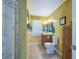 Well-lit bathroom features a vanity with storage, a toilet, and a shower with floral curtain at 906 Hacienda Dr, Sun City Center, FL 33573