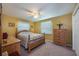 Cozy bedroom features a four-poster bed, two windows, and traditional wooden furnishings at 906 Hacienda Dr, Sun City Center, FL 33573