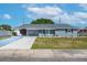 Charming single-story home with a carport, well-manicured lawn, and lovely landscaping at 906 Hacienda Dr, Sun City Center, FL 33573