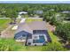 Home with a refreshing screened-in pool and patio, surrounded by verdant greenery and blue skies at 9091 Mazette Rd, Weeki Wachee, FL 34613