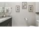Bathroom featuring granite countertop, dark cabinets, framed artwork, and toilet paper holder at 9091 Mazette Rd, Weeki Wachee, FL 34613