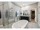 Bright bathroom with a glass shower, soaking tub, granite vanity and walk-in closet at 9091 Mazette Rd, Weeki Wachee, FL 34613