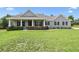 Charming single-story home featuring a covered front porch, manicured lawn, and lush landscaping at 9091 Mazette Rd, Weeki Wachee, FL 34613