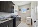 Contemporary laundry room with dark cabinetry, sink, and modern washer and dryer at 9091 Mazette Rd, Weeki Wachee, FL 34613