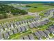 An aerial view displays residences close to green spaces, water features, and a school at 9324 Rally Spring Loop, Wesley Chapel, FL 33545